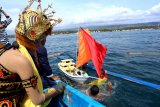 Warga melarung sesaji dalam kapal kecil saat tradisi rabu Wekasan di Pantai Waru Doyong, Banyuwangi, Jawa Timur, Rabu (7/11/2018). Pada hari Rabu wekasan (hari Rabu terakhir di bulan Safar) ini, diperingati oleh warga pesisir dengan tradisi doa dan petik laut, sebagai tolak bala. Antara Jatim/Budi Candra Setya/ZK.