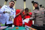 Polisi menunjukkan tersangka kasus peredaran narkoba serta barang bukti di Polrestabes Surabaya, Jawa Timur, Selasa (27/11/2018).  Satresnarkoba Polrestabes Surabaya menangkap seorang warga negara asing (WNA) asal Amerika Serikat berinisial ADE (28) serta seorang warga negara Indonesia berinisial APE (42) atas dugaan kepemilikan narkoba jenis ganja dan sabu-sabu yang disimpan dan dipakai bersama oleh kedua tersangka di tempat tinggal ADE di salah satu apartemen di kawasan Tenggilis, Surabaya. Antara Jatim/Didik Suhartono/ZK.