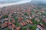     Foto udara kawasan rumah yang digenangi air luapan Sungai Batanghari di Kecamatan Pelayangan, Jambi, Rabu (14/11/2018). Ratusan rumah panggung di sejumlah titik tepian Sungai Batanghari kota itu terendam menyusul tingginya intensitas hujan di bagian hulu, sementara BPBD setempat menyebutkan hampir semua kawasan di sepanjang aliran Sungai Batanghari provinsi itu berstatus rawan banjir selama musim hujan. ANTARA FOTO/Wahdi Septiawan/hp.
