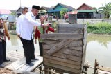 Bupati Banjar H Khalillurrahman disaksikan oleh Kepala SKPD Kabupaten Banjar, Wakil Ketua DPRD Kabupaten Banjar, Camat Martapura Barat serta Kepala Desa Antasan Sutun dan Tokoh Masyarakat membongkar  jamban Apung yang berada di bantaran sungai Martapura , di Desa Antasan Sutun Kecamatan Martapura Barat  Rabu (07/11) dalam rangka program lanjutan 
Pengangkatan Jamban Terapung. Foto Antaranews Kalsel/hms/f 