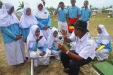 Petugas Badan Meteorologi Klimatologi dan Geofisika (BMKG) menerangkan cara kerja alat pengukur tingkat penguapan air dalam tanah pada siswa Madrasah Arrayadlah (MA) Paiton-Probolinggo di Stasioun BMKG Krangploso, Malang, Jawa Timur, Selasa (6/11/2018). Kegiatan pembelajaran luar kelas yang diikuti 65 siswa tersebut bertujuan mengenalkan hal-hal yang berkaitan dengan prakiraan cuaca, iklim serta perhitungan awal musim hujan. Antara Jatim/Ari Bowo Sucipto/ZK