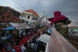 Seorang warga menebarkan uang kepada peserta pawai Maulid Nabi di Surabaya, Jawa Timur, Senin (19/11/2018). Pawai yang diikuti ratusan warga, murid dan guru Taman Pendidikan Alquran (TPA) di kampung nelayan Nambangan dan Bulak Cumpat tersebut dalam rangka memperingati hari lahirnya Nabi Muhammad SAW. Antara Jatim/Moch Asim/ZK