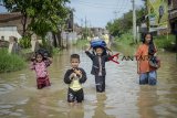 Sejumlah anak melintasi banjir yang melanda Andir, Kabupaten Bandung, Jawa Barat, Jumat (30/11/2018). Hujan lebat pada Kamis (29/11) yang mengguyur Bandung raya menyebabkan banjir setinggi 60 hingga 100 sentimeter akibat luapan Sungai Citarum. ANTARA JABAR/Raisan Al Farisi/agr.