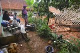 Warga menyaksikan rumah yang tertimbun material tanah longsor di Desa Bojongsari, Kabupaten Tasikmalaya, Jawa Barat, Kamis (8/11/2018). Curah hujan yang tinggi di daerah Tasikmalaya Selatan mengakibatkan sembilan rumah tertimbun tanah longsor dan sebanyak 2.045 jiwa terdampak bencana longsor serta banjir dari 10 Desa yang ada di Kabupaten Tasikmalaya. ANTARA JABAR/Adeng Bustomi/agr.