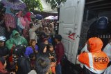 Antrean warga saat pembagian paket sembako untuk korban terdampak longsor dan banjir di Desa Bojongsari, Kabupaten Tasikmalaya, Jawa Barat, Jumat (9/11/2018). Kementerian Sosial menyalurkan bantuan sebesar Rp.962.558.750 kepada pemerintah Kabupaten Tasikmalaya, terdiri dari santunan kepada enam korban meninggal dunia akibat banjir bandang sebesar Rp.90.000.000 dan bantuan logistik sebesar Rp.853.855.750. ANTARA JABAR/Adeng Bustomi/agr.