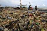 Nelayan menyandarkan perahunya di bibir pantai yang dipenuhi sampah plastik di Desa Dadap, Indramayu, Jawa Barat, Senin (26/11/2018). LSM World Wild Fund for Nature (WWF) Indonesia menilai masalah pencemaran sampah plastik di laut Indonesia sudah bisa disebut sebagai darurat sampah plastik karena perlu penanganan serius. ANTARA JABAR/Dedhez Anggara/agr.