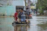 Warga menggunakan perahu karet melintasi banjir yang melanda Kampung Bojong Asih, Dayeuhkolot, Kabupaten Bandung, Senin (12/11/2018). Banjir hingga 1,5 meter tersebut disebabkan oleh luapan Sungai Citarum serta intensitas hujan yang tinggi beberapa hari terakhir di wilayah Kabupaten Bandung. ANTARA JABAR/Raisan Al Farisi/agr.