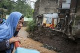 Warga melihat sejumlah rumah yang rusak akibat longsornya tembok pembatas aliran air di bantaran Sungai Cidurian, Bandung, Jawa Barat, Senin (26/11/2018). Sedikitnya lima rumah warga terancam ambruk akibat tembok yang tergerus luapan air Sungai Cidurian karena tingginya intensitas curah hujan di Kota Bandung. ANTARA JABAR/Novrian Arbi/agr.