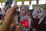 Petugas medis memberikan suntikan imunisasi Measles Rubella (MR) di SDN Kertajaya, Salopa, Kabupaten Tasikmalaya, Jawa Barat, Selasa (13/11/2018). Kemenkes menargetkan pencapaian program imunisasi MR untuk 70 juta anak menjadi 85 persen, dari target awal 95 persen. ANTARA JABAR/Adeng Bustomi/agr.