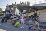 Wisatawan asing menyeret koper pascagempa di Kecamatan Pemenang,Tanjung, Lombok Utara, NTB, Senin (6/8/2018). ANTARA FOTO/Ahmad Subaidi.