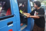 Petugas Kejaksaan membagikan stiker dan souvenir mug dalam aksi simpatik Peringatan Hari Anti Korupsi di depan Balaikota Malang, Jawa Timur, Senin (10/12/2018). Aksi yang dilakukan di sejumlah titik tersebut melibatkan puluhan jaksa dan pegawai kejaksaan sebagai upaya untuk meningkatkan kesadaran masyarakat serta aparatur pemerintahan tentang tindak korupsi. Antara Jatim/Ari Bowo Sucipto/ZK.