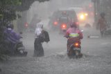 Pengguna jalan berusaha melintasi genangan banjir di jalan Gajayana, Malang, Jawa Timur, Senin (10/12/2018). Hujan deras yang melanda kawasan tersebut mengakibatkan banjir di sejumlah titik.  Antara Jatim/HO/H Prabowo/ZK.