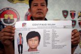 Petugas menunjukkan sketsa wajah yang diduga pelaku saat rilis di halaman Mapolres Blitar, Jawa Timur, Jumat (30/11/2018). Setelah melakukan penyidikan, Polisi akhirnya merilis rekaman dan sketsa wajah seorang terduga pelaku pembuat surat pemanggilan berlogo Komisi Pemberantasan Korupsi (KPK) yang diduga palsu terhadap Bupati, Kepala Dinas PUPR dan Ketua DPRD Blitar beberapa waktu lalu, sekaligus juga menetapkan terduga sebagai DPO. Antara Jatim/Irfan Anshori/ZK