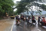 Sejumlah pengendara melintasi jalan JLS yang masih tergenang air sisa banjir bandang yang melanda Desa Kebonagung, Pacitan, Jawa Timur, Sabtu (8/12).  Bencana banjir dan tanah longsor di Pacitan yang terjadi sejak Jumat (7/12) malam telah menyebabkan empat warga tewas tertimbun material longsor dan beberapa ruas jalan JLS setempat terputus beberapa jam akibat terendam banjir. Antara Jatim/Riska/Ds/ZK.