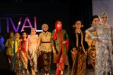 Model berjalan memperagakan busana pada Festival Kebaya di Banyuwangi, Jawa Timur, Rabu (5/12/2018). Ajang yang menampilkan 100 karya kebaya semi modern hasil kolaborasi perancang nasional dengan desainer lokal Banyuwangi itu sebagai upaya mendorong minat kawula muda agar berkebaya sebagai alternatif berbusana guna menjaga tradisi warisan leluhur. Antara Jatim/Budi Candra Setya/ZK.