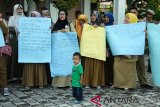 Sejumlah guru honor Kategori 2 (K2) yang tergabung dalam Asosiasi Gurun Aceh membubuhkan tandatangan pada spanduk saat menggelar aksi damai di gedung DPRA, Banda Aceh, Rabu (12/12/2018). Guru honor K2 yang sudah lulus tes CPNS Panitia Seleksi Nasional mendesak DPRA memperjuangkan nasibnya agar pemerintah pusat dan pemerintah Aceh menerbitkan SK pengangkatan sebagai PNS dan menolak rencana penetapan Pegawai Pemerintah dengan Perjanjian Kerja (P3K) oleh pemerintah pusat. (Antara Aceh/Ampelsa)