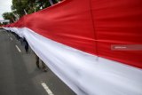 Peserta gerak jalan perjuangan Mojokerto Surabaya membawa bendera Merah Putih Sepanjang 180 m di garis start Prajuritkulon, Kota Mojokerto,  Jawa Timur, Sabtu (1/12/2018). Gerak jalan Mojokerto-Surabaya sejauh 55 KM tersebut sebagai bentuk napak tilas perjuangan pahlawan ini menjadi rangkaian kegiatan  peringatan Hari Pahlawan. Antara Jatim/Umarul Faruq/ZK