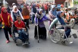 Sejumlah penyandang disabilitas fisik mengikuti jalan sehat bersama insan disabilitas di Surabaya, Jawa Timur, Minggu (2/12/2018). Kegiatan yang diikuti sekitar 2.700 peserta dari 119 kelompok dan lembaga se-Jawa Timur tersebut untuk menyemarakkan Hari Disabilitas Internasional 2018. Antara Jatim/M Risyal Hidayat/ZK