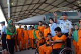 Komandan Lanud Iswahjudi Marsma TNI Widyargo Ikoputra (kanan) dan isterinya, Yanti Ikoputra (kedua kanan) berbincang dengan anak-anak penyandang disabilitas di Skadron Udra 14 Lanud Iswahjudi, Magetan, Jawa Timur, Kamis (6/12/2018). Dalam rangka peringatan Hari Disabilitas Internasional, Lanud Iswahjudi mengundang anak-anak penyandang disabilitas untuk melihat pesawat tempur dan mengikuti pembinaan mental guna memberikan motivasi kepada mereka. Antara Jatim/Siswowidodo/ZK.