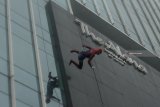 Seorang karyawan berkostum Spiderman menuruni gedung hotel Alana saat acara 