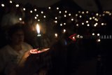 Jemaat kristiani menyalakan lilin saat prosesi ibadah malam Natal di GKI maulana Yusuf, Bandung, Jawa Barat, Senin (24/12/2018) malam. Umat Kristiani merayakan Hari Raya Natal pada 25 Desember. ANTARA JABAR/M Agung Rajasa/agr