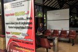 Pemohon paspor menunggu antrian didekat banner pemberantasan calo di Kantor Imigrasi Kelas II Non TPI Blitar, jawa Timur, Selasa (4/12/2018). Indeks kepuasan masyarakat (IKM) pada pelayanan di Kanim Blitar tercatat mencapai nilai 90 dengan predikat A pada semester II tahun 2018, jumlah tersebut terus naik seiring dengan semakin meningkatnya kualitas pelayanan di kantor tersebut. Antara Jatim/Irfan Anshori/ZK.