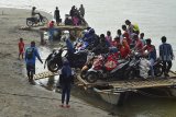 Warga menggunakan kendaraan bermotor menyebrangi sungai menggunakan perahu di Sungai Muara Cipatujah, Kabupaten Tasikmalaya, Jawa Barat, Kamis (13/12/2018). Akibat Jembatan Pansel Cipatujah ambruk diterjang banjir bandang atau pembangunan jembatan bailey belum rampung membuat sejumlah warga beraktifitas menggunakan jasa penyebrangan sungai menggunakan perahu nelayan dengan tarif penyerbrangan sekitar Rp 5.000 hingga Rp 10.000 sekali per motor. ANTARA JABAR/Adeng Bustomi/agr. 