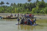 Warga menggunakan kendaraan bermotor menyebrangi sungai menggunakan perahu di Sungai Muara Cipatujah, Kabupaten Tasikmalaya, Jawa Barat, Kamis (13/12/2018). Akibat Jembatan Pansel Cipatujah ambruk diterjang banjir bandang atau pembangunan jembatan bailey belum rampung membuat sejumlah warga beraktifitas menggunakan jasa penyebrangan sungai menggunakan perahu nelayan dengan tarif penyerbrangan sekitar Rp 5.000 hingga Rp 10.000 sekali per motor. ANTARA JABAR/Adeng Bustomi/agr. 