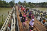 Warga menyebrang di Jembatan Bailey Pansel yang sudah bisa dilalui pasca putus akibat diterjang banjir bandang di Desa Ciheras, Cipatujah, Kabupaten Tasikmalaya, Jawa Barat, Kamis (13/12/2018). Jembatan tersebut baru diresmikan untuk bisa dilalui kembali para pengguna jalan dan kendaraan oleh Direktorat Jenderal Bina Marga Kementerian PUPR. ANTARA JABAR/Adeng Bustomi/agr.