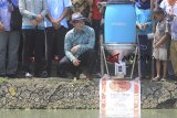 Gubernur Jawa Barat Ridwan Kamil melihat proses pemberian pakan dengan mesin automatic fish feeder saat peluncuran program Kampung Perikanan Digital di Losarang, Indramayu, Jawa Barat, Senin (10/12/2018). Kampung Perikanan Digital tersebut menerapkan teknologi berbasis aplikasi smartphone untuk mengontrol tambak ikan sehingga mampu memberikan efisiensi pemberian pakan dan mempercepat siklus panen. ANTARA JABAR/Dedhez Anggara/agr.