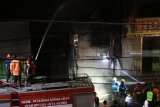 Petugas berusaha memadamkan api yang membakar toko elektronik di Kediri, Jawa Timur, Rabu (5/12/2018). Penyebab kebakaran di kawasan pusat pertokoan tersebut masih dalam tahap penyelidikan pihak kepolisian. Antara Jatim/Prasetia Fauzani/ZK.