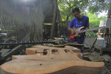 Perajin menyelesaikan pesanan gitar eletrik di industri gitar rumahan L-Bner, Lobener, Jatibarang, Indramayu, Jawa Barat, Kamis (13/12/2018). Gitar yang banyak dipesan musisi lokal maupun nasional tersebut dijual seharga Rp2 juta hingga 15 juta per unit. ANTARA JABAR/Dedhez Anggara/agr. 