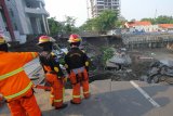 Tim Orong-Orong dari Dinas Pemadam Kebakaran Kota Surabaya memeriksa lokasi tanah ambles di Jalan Raya Gubeng, Surabaya, Jawa Timur, Rabu (19/12/2018). Jalan raya tersebut ambles sedalam sekitar 20 meter dengan lebar 30 meter pada Selasa (18/12/2018) malam diduga karena proyek pembangunan gedung di sekitar lokasi dan pihak kepolisian memeriksa intensif lima pekerja proyek dalam kejadian itu. Antara Jatim/Didik Suhartono/ZK.