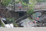 Petugas memotret lokasi tanah ambles di Jalan Raya Gubeng, Surabaya, Jawa Timur, Rabu (19/12/2018). Jalan raya tersebut ambles sedalam sekitar 20 meter dengan lebar 30 meter pada Selasa (18/12/2018) malam diduga karena proyek pembangunan gedung di sekitar lokasi dan pihak kepolisian memeriksa intensif lima pekerja proyek dalam kejadian itu. Antara Jatim/Didik Suhartono/ZK.