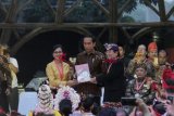     Presiden Joko Widodo (tengah) menerima strategi kebudayaan yang diserahkan Aktris Nungki Kusumastuti (kiri) dan Budayawan I Made Bandem (kanan) pada Kongres Kebudayaan Indonesia 2018 di Jakarta, Minggu (9/12/2018). Kongres tersebut untuk memperkuat dan memoles hasil kerja seluruh insan kebudayaan di Indonesia yang dilakukan sejak Maret 2018. ANTARA FOTO/Rivan Awal Lingga/ama.