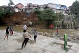 Sejumlah anak bermain sepak bola di bantaran sungai Cisadane Kota Bogor, Jawa Barat, Selasa (11/12/2018). Kurangnya fasilitas sosial seperti tempat olahraga atau taman bermain yang memadai di permukiman padat penduduk  menyebabkan anak-anak bermain di lokasi yang relatif berbahaya. ANTARA JABAR/Yulius Satria Wijaya/agr. 