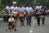 Peserta mengikuti Lari Amal Pelindo (Pelindo Charity Run) 2018 di kawasan Pelabuhan Tanjung Perak, Surabaya, Jawa Timur, Minggu (16/12/2018). Lari Amal Pelindo dalam rangka HUT ke-26 Pelindo itu diikuti sekitar 5.000 peserta yang dana terkumpul akan disalurkan untuk membantu korban musibah gempa-tsunami di Palu dan Donggala, Sulawesi Tengah. Antara Jatim/Didik Suhartono/ZK.