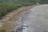 Wisatawan menikmati keindahan Pantai Gemah di pesisir selatan Tulungagung, Jawa Timur, Selasa (25/12). Kunjungan wisatawan di Pantai Gemah yang lokasinya tak jauh dari perlintasan jalur lintas selatan (JLS) tersebut meningkat tiga kali lipat (300 persen) selama musim libur sekolah, libur Natal dan Tahun Baru 2019, yakni rata-rata 4.000-an kunjungan/hari pada hari libur biasa (Sabtu-Minggu) melonjak hingga kisaran rata-rata 12 ribuan wisatawan. Antara Jatim/Destyan Sujarwoko/ZK.