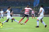 Pesepak bola Madura United (MU) Mamadou Samassa (tengah) berusaha melewati pesepak bola Persela Lamongan Arif Satria dalam kompetisi Liga 1 di Stadion Gelora Ratu Pamelingan (SGRP) Pamekasan, Jawa Timur, Sabtu (8/12/2018). MU unggul 2-1 atas persela. Antara Jatim/Saiful Bahri/ZK.