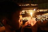 Sejumlah umat Kristiani membawa lilin ketika melakukan doa pada Misa Natal di Gereja Bethany Surabaya, Jawa Timur, Senin (24/12/2018). Perayaan Natal 2018 bertemakan 