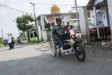 Iman Suwandi mencoba motor listrik penarik kursi roda di Kampung Inggris, Sukaraja, Kabupaten Sukabumi, Jawa Barat, Rabu (13/12/2018). Iman telah menghabiskan dana sebesar Rp11 juta untuk membuat motor listrik penarik kursi roda bertenaga baterai, motor tersebut mampu menempuh jarak sejauh 45 km dengan kecepatan maksimal 50 km per jam. ANTARA JABAR/Nurul Ramadhan/agr.