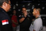 Kepala Bidang Pemberantasan Badan Narkotika Nasional Provinsi (BNNP) Jawa Timur  AKBP Wisnu Chandra (ketiga kanan) memeriksa mata pengunjung salah satu tempat hiburan malam saat Operasi Penegakan Ketertiban (Gaktib) dan Yustisi POM TNI 2018 di Surabaya, Jawa Timur, Kamis (6/12/2018) malam. Operasi gabungan Polisi Militer TNI AL, TNI AU, TNI AD, Polri dan Badan Narkotika Nasional Provinsi (BNNP) Jawa Timur di sejumlah tempat hiburan malam itu dilaksanakan guna terciptanya kepatuhan hukum, disiplin dan tata tertib di lingkungan TNI, sehingga dapat menekan tingkat pelanggaran dan mencegah timbulnya perbuatan melawan hukum oleh personel TNI. Antara Jatim/Didik Suhartono/ZK.