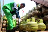 Seorang petugas menyusun tabung gas subsidi saat gelar operasi pasar Pertamina di Polsek Pontianak Barat, Kalimantan Barat, Senin (17/12/2018). PT Pertamina (Persero) wilayah Kalbar menggelar operasi pasar gas bersubsidi 3 kilogram dengan harga eceran tertinggi (HET) sebesar Rp16.500 per tabung di sejumlah titik di Kota Pontianak guna normalisasi harga serta menjamin ketersediaan menyusul terjadinya kelangkaan. ANTARA FOTO/Jessica Helena Wuysang 

