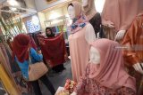 Pengunjung mengamati hijab yang dipamerkan di salah satu stan ketika berlangsungnya Indonesia Sharia Economic Festival (ISEF) 2018 di Surabaya, Jawa Timur, Rabu (12/12/2018). ISEF 2018 yang mengusung tema 