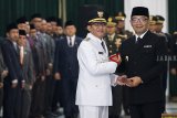 Gubernur Jawa Barat Ridwan Kamil (kanan) berjabat tangan dengan Bupati Tasikmalaya Ade Sugianto (kedua kanan) saat upacara pengambilan sumpah jabatan dan pelantikan Bupati Tasikmalaya di Gedung Sate, Bandung, Jawa Barat, Senin (3/12/2018). Ade Sugianto resmi menjabat sebagai Bupati Tasikmalaya menggantikan Uu Ruzhanul Ulum dengan sisa masa jabatan tahun 2016-2021. ANTARA JABAR/M Agung Rajasa/agr.
