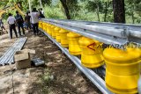 Pekerja menyelesaikan pembangunan Roller Barrier atau pembatas jalan bersilender putar di jalur letter S Cikidang-Palabuhanratu, Cikidang, Kabupaten Sukabumi, Jawa Barat, Jumat (28/12/2018). Roller Barrier yang dipasang sepanjang 60 meter tersebut merupakan pertama di Indonesia dan Gubernur Jabar Ridwan Kamil berencana akan memasang Roller Barrier di jalan besar antar Kota antar Provinsi yang berliku dan banyak melewati jurang sebagai salah satu langkah mengurangi angka kecelakaan di Jawa Barat. ANTARA JABAR/Nurul Ramadhan/agr. 