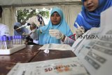 Petugas memeriksa sampel darah saat pemeriksaan HIV/AIDS gratis dalam rangka memperingati hari AIDS sedunia di Indramayu, Jawa Barat, Sabtu (1/12/2018). Pemeriksaan tersebut dilakukan untuk mengetahui sejak dini penyebaran HIV/AIDS pada masyarakat. ANTARA JABAR/Dedhez Anggara/agr.