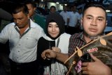 Penyanyi Dangdut Via Vallen (tengah) bergegas usai menjalani pemeriksaan di Ruang Subdit IV Tindak Pidana Tertentu (Tipidter) Direktorat Kriminal Khusus (Ditreskrimsus) Polda Jawa Timur, Surabaya, Kamis (20/12/2018). Via Vallen menjalani pemeriksaan sebagai saksi terkait kasus penjualan kosmetik ilegal dari Derma Skin Care. Antara Jatim/M Risyal Hidayat/ZK.