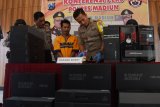 Kapolres Madiun AKBP Ruruh Wicaksono (kanan) memperlihatkan barang bukti di dekat tersangka Khoirul (tengah) saat merilis pengungkapan kasus pencurian 22 unit komputer di Polres Madiun, Jawa Timur, Rabu (12/12/2018). Tersangka khoirul warga Jakarta Utara bersama tiga orang tersangka lainnya melakukan pencurian 22 unit computer di SMPN 2 Gemarang, Kabupaten Madiun. Antara Jatim/Siswowidodo/ZK.