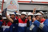 Menteri ESDM Ignasius Jonan (tengah) berswafoto dengan pekerja PT Pertamina (Persero) saat berkunjung ke Terminal Bahan Bakar Minyak (TBBM) Surabaya Group di Surabaya, Jawa Timur, Senin (24/12/2018). Kunjungan tersebut dalam rangka pengawasan lapangan terhadap penyediaan dan pendistribusian BBM sekaligus tindak lanjut dari pembentukan tim Posko Nasional Energi dan Sumber Daya Mineral dalam menyambut Hari Natal dan Tahun Baru 2019. Antara Jatim/Moch Asim/ZK.